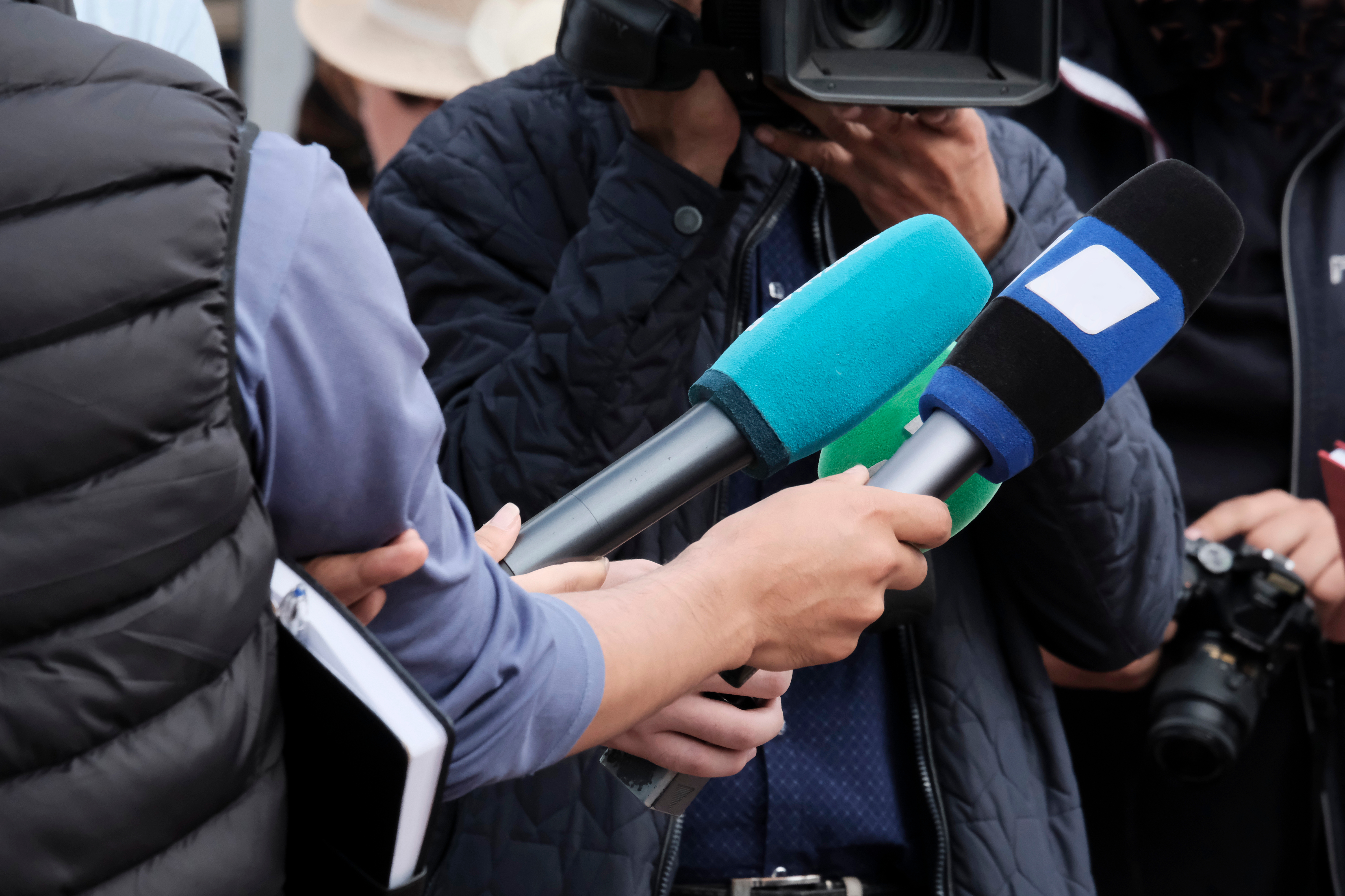 Microphones being held up for a statement at a press conference