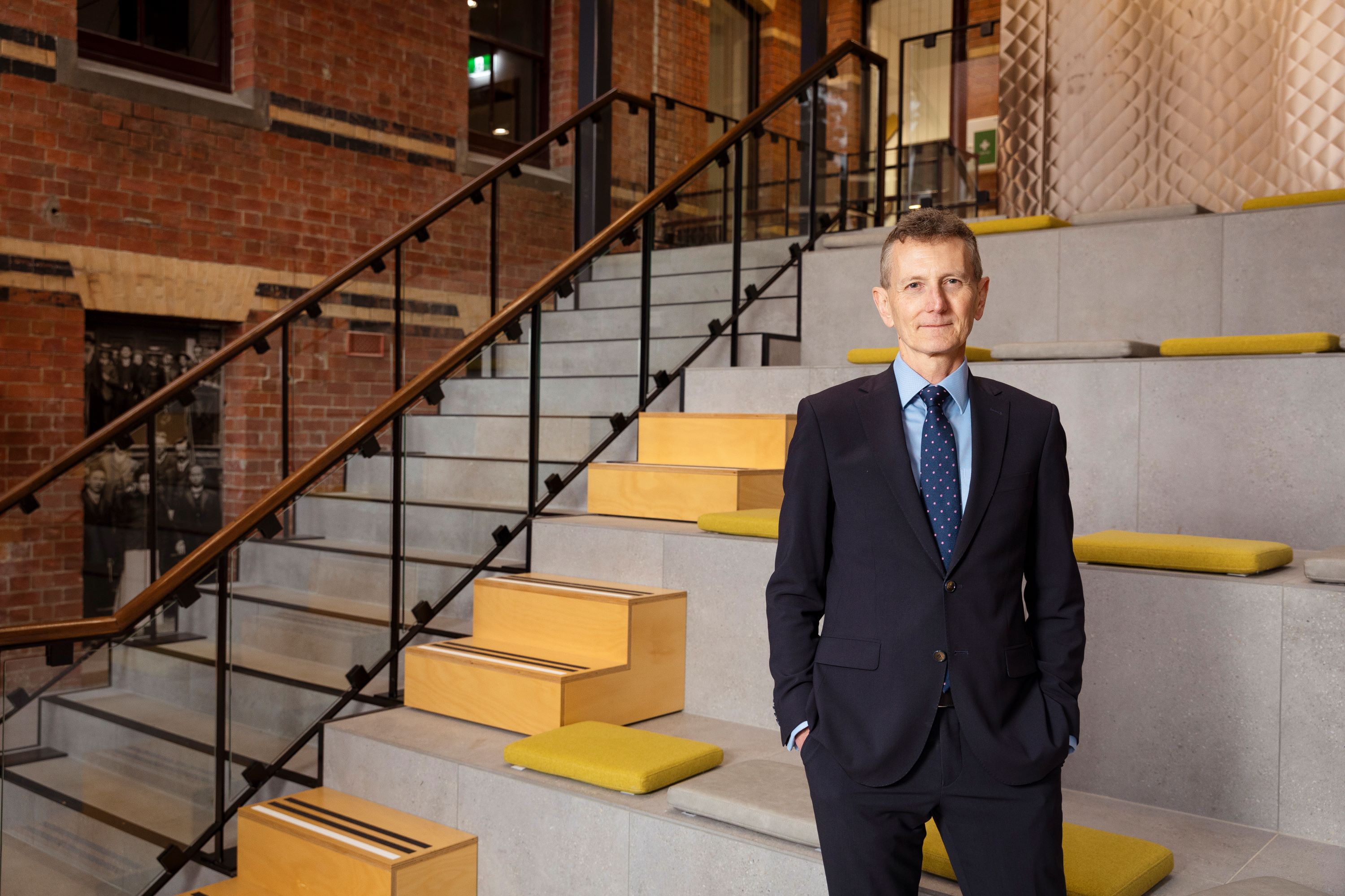 Man wearing a suit standing in front of a stairwell