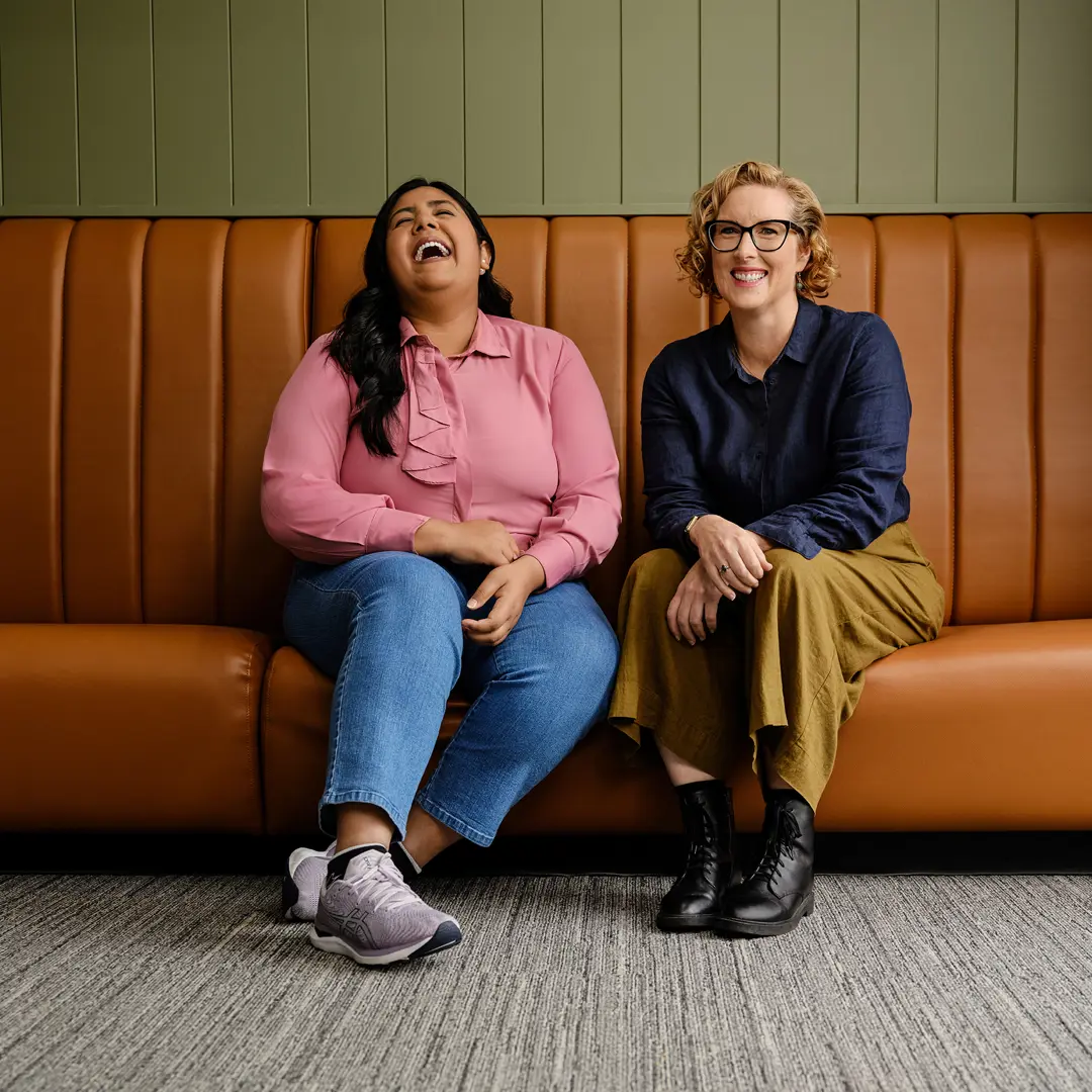 Photo of two happy people sitting on a vintage sofa.