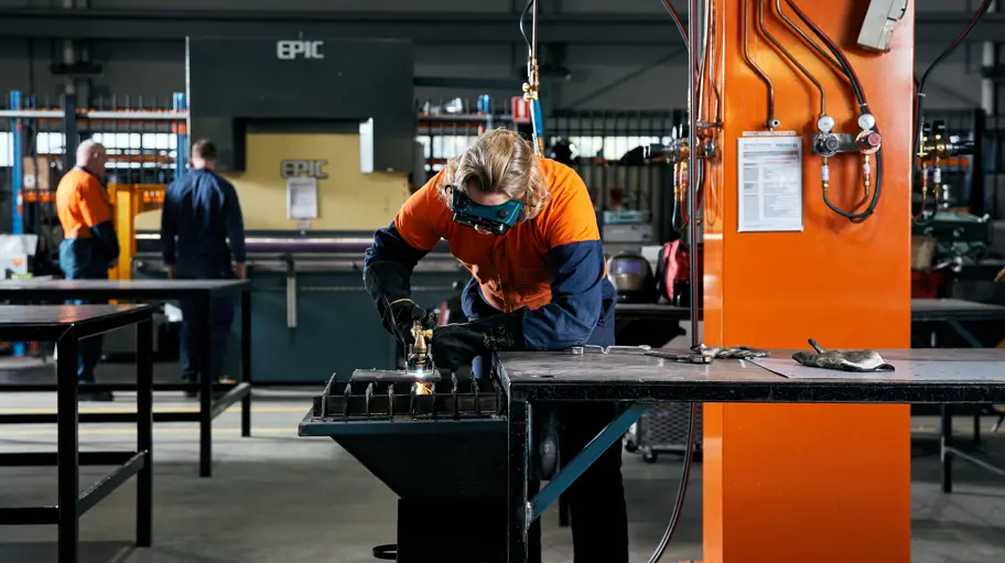 Photo of a tradesperson working on a machine in a workshop.