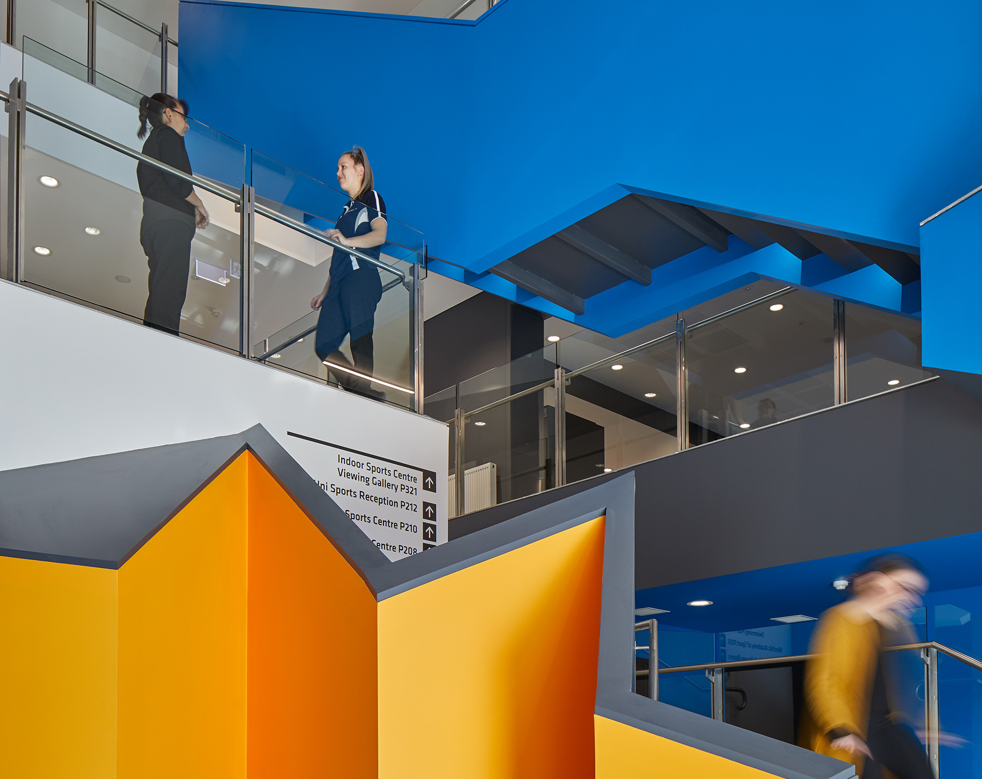 Two students standing in a modern building.