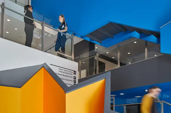 Two students standing in a modern building.