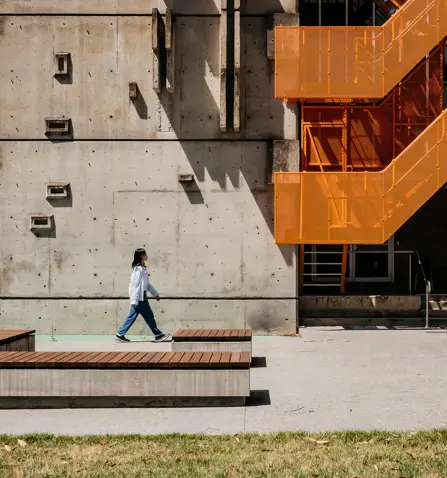 Person walking near modern building on Mt Helen Campus.