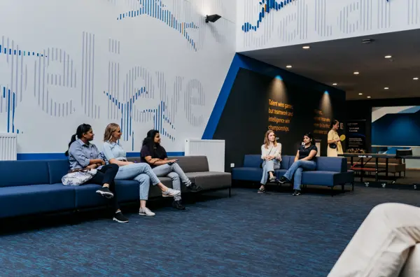 Students sitting on couches in a modern communal campus space.