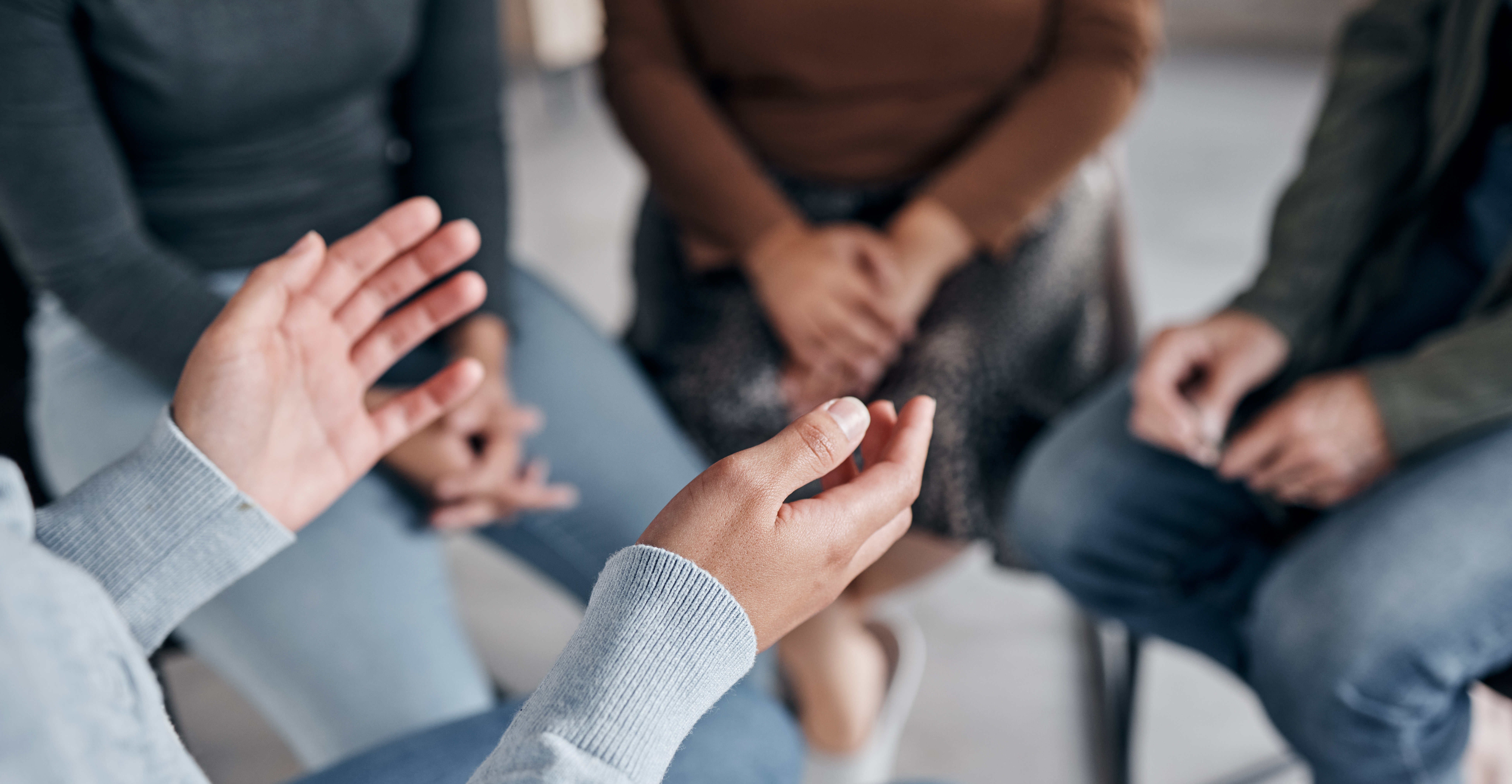 Photo of a pair of hands, in the background there are blurred legs