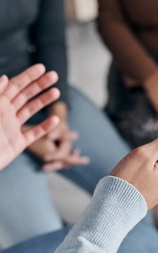 Photo of a pair of hands, in the background there are blurred legs